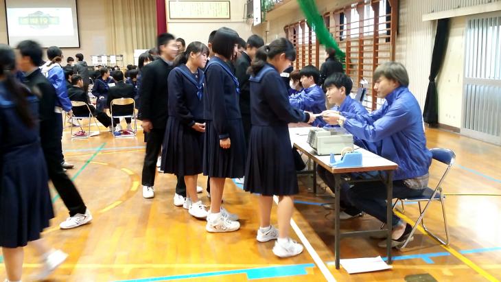 投票用紙の交付を受ける学生